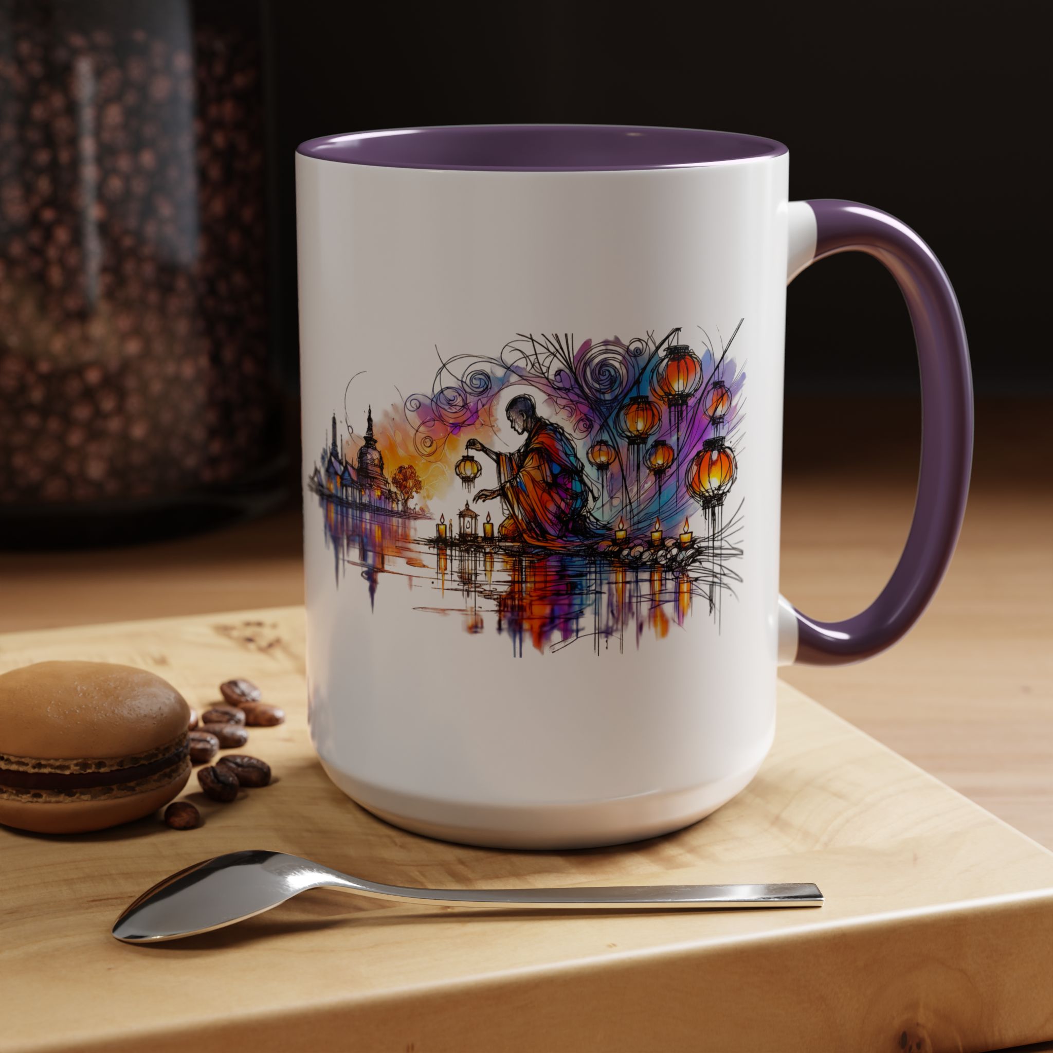 A white mug with a colorful artistic design featuring a figure by a water body, accompanied by a macaron and a spoon.