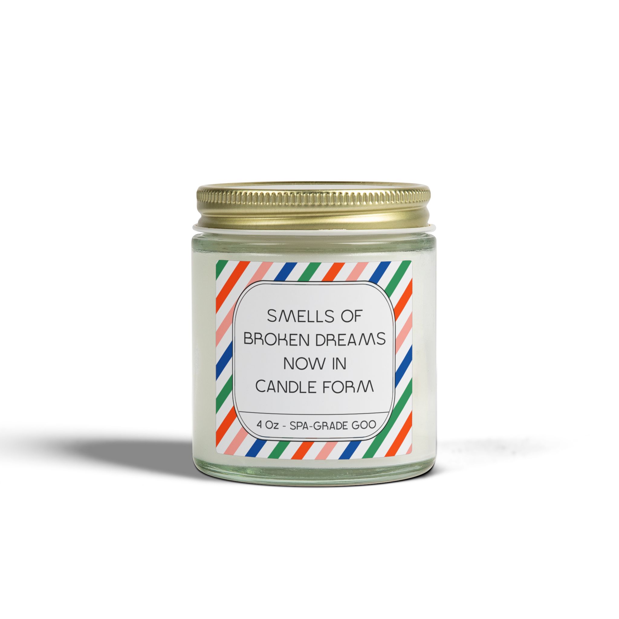 A 4 oz candle in a clear glass jar with a colorful label stating 'Smells of Broken Dreams Now in Candle Form'.